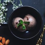 بستنی شکلاتی با تزیین برگ نعنا در فنجان سیاه در کافه چی